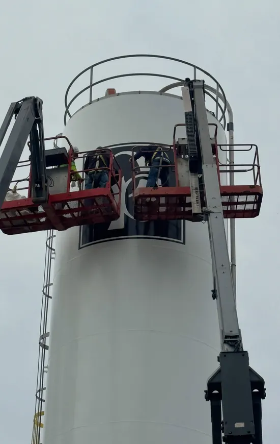 Lift-certified crew coating an industrial silo