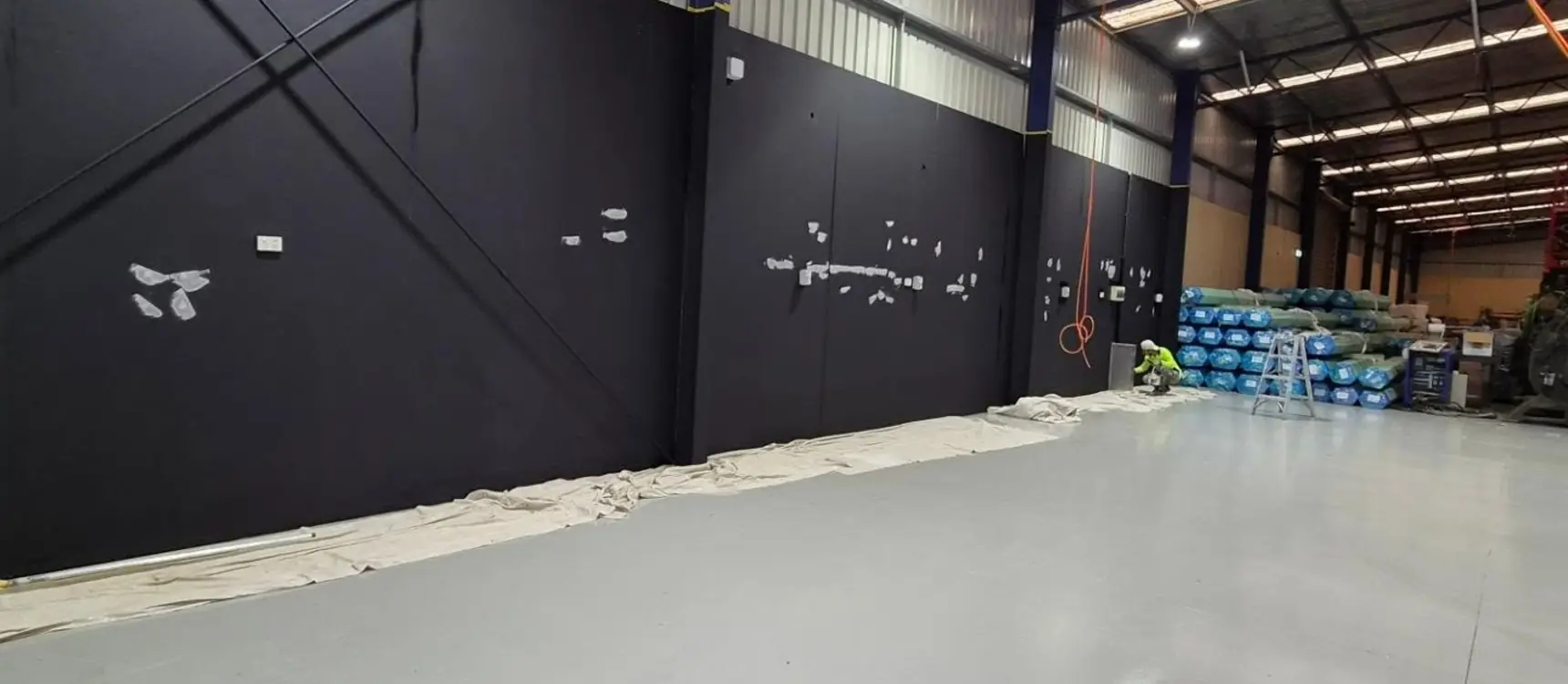 Warehouse with charcoal walls and gray epoxy floor
